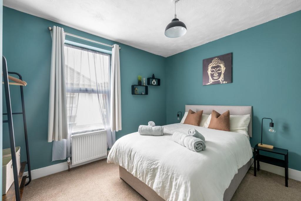 um quarto com paredes azuis e uma cama em Shamrock House- 2 BR House, Free Parking & WIFI em Ipswich