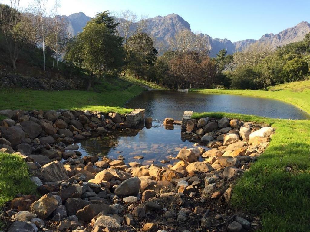een stroom van rotsen en water met bergen op de achtergrond bij Wechmarshof in Stellenbosch