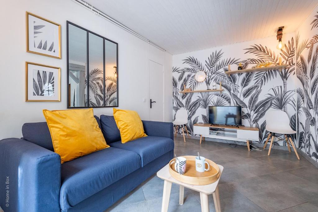 un salon avec un canapé bleu et une télévision dans l'établissement Maison atypique et familiale, proche Disney avec Wifi, à Chessy