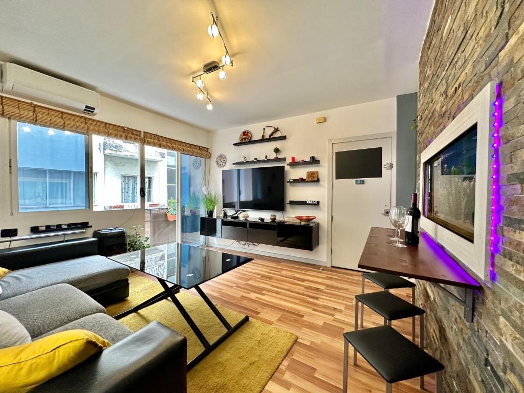 Una sala de estar con un sofá y un televisor. en Sabino Street Apartment, en Santa Cruz de Tenerife