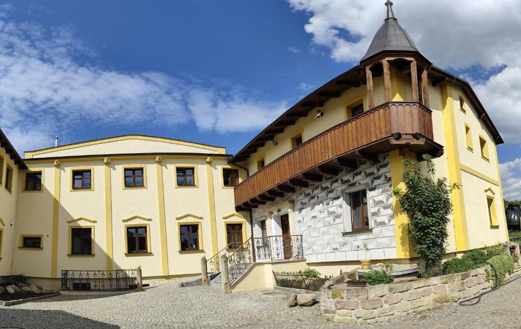 un gran edificio amarillo con techo de madera en Hotel u Jindry en Železnice