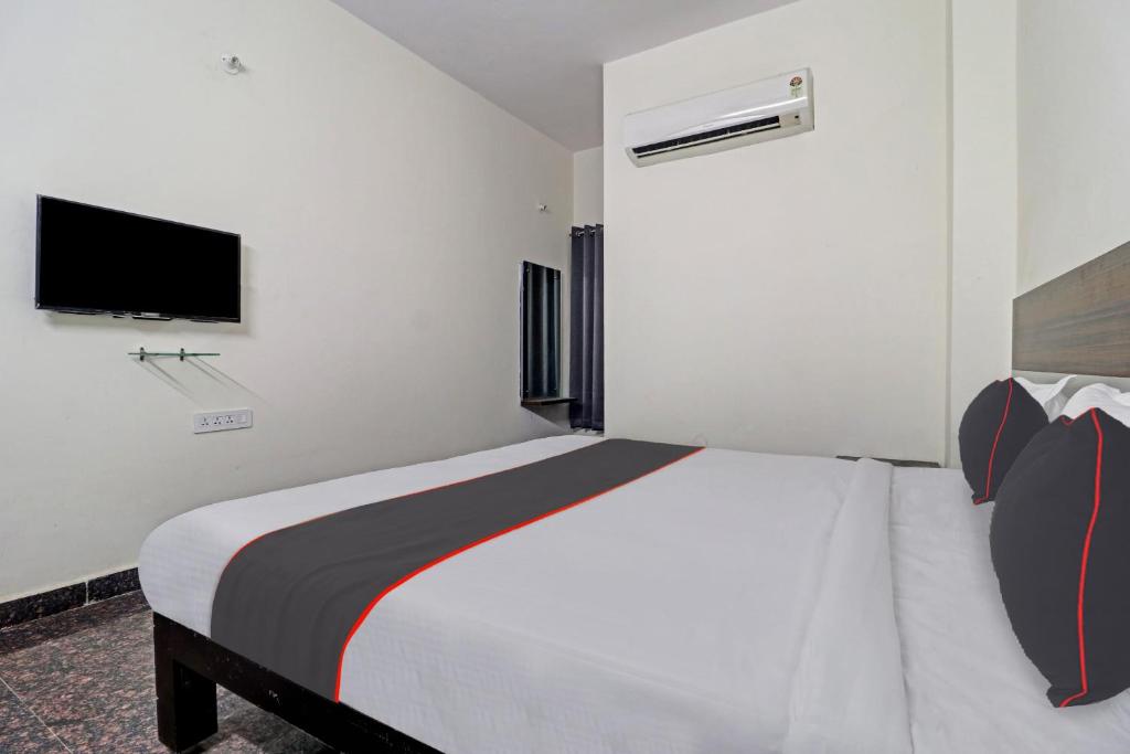 a bedroom with a large bed and a tv at 80977E SS Metro Ritz in Ameerpet