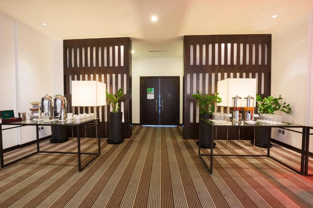 une chambre avec deux tables et des verres dans l'établissement Holiday Inn Abu Dhabi, an IHG Hotel, à Abu Dhabi