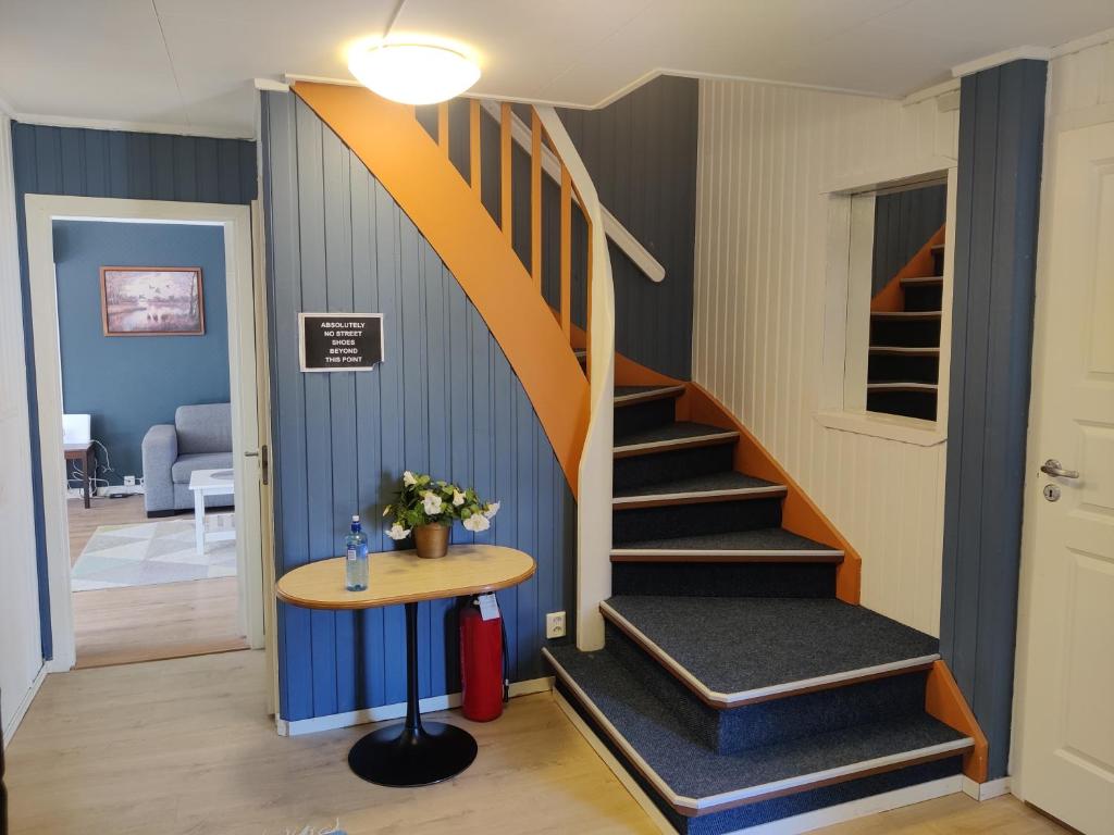 a staircase in a room with a table and a stair case at FeelHome 4 bedrooms apartment Polarvegen in Tromsø