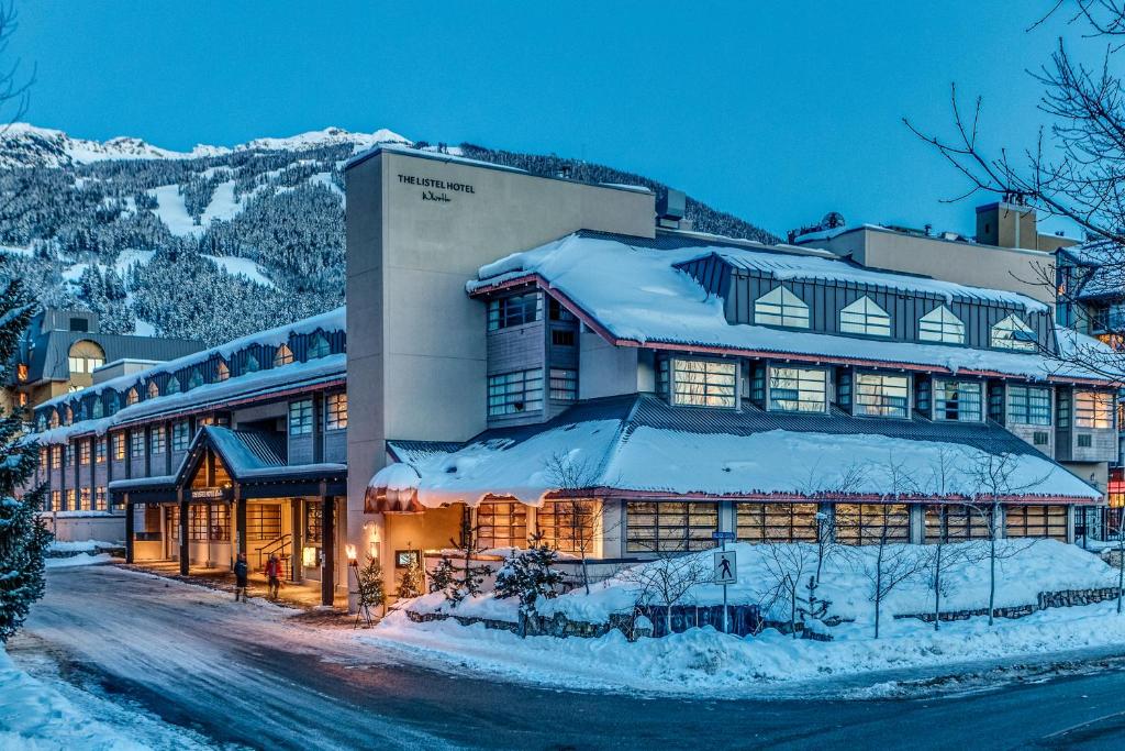 ein Hotel im Schnee mit einem Gebäude in der Unterkunft The Listel Hotel Whistler in Whistler