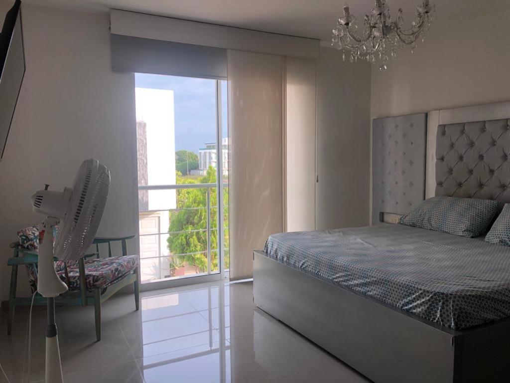 sypialnia z łóżkiem, wentylatorem i oknem w obiekcie Casa Esquina Condominio Diomedes Daza Valledupar w mieście Valledupar