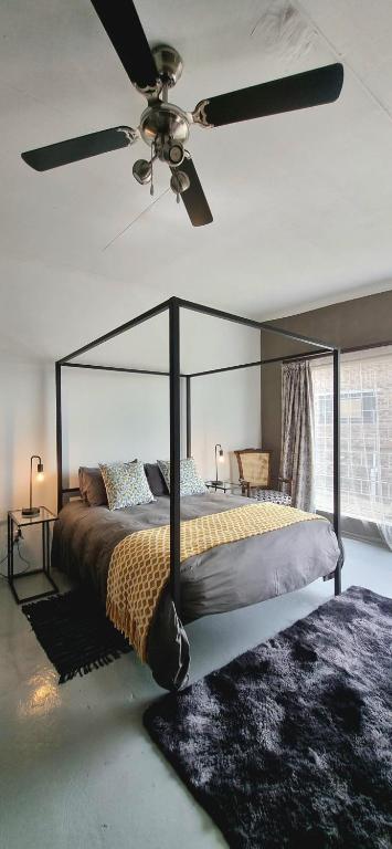 a bedroom with a bed with a ceiling fan at Rand Self-catering Accommodation in Carolina