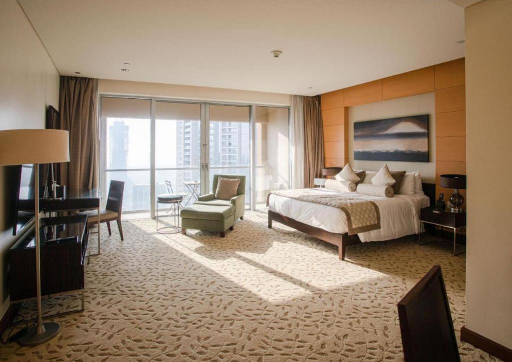 a hotel room with a bed and a desk and chair at Emaar Residences Fashion Avenue, formerly Address Dubai Mall in Dubai