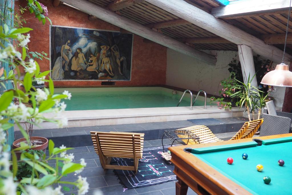 a swimming pool with a pool table and a pool table at Chambres d'Hôtes Le relais des marmottes in Lagnes