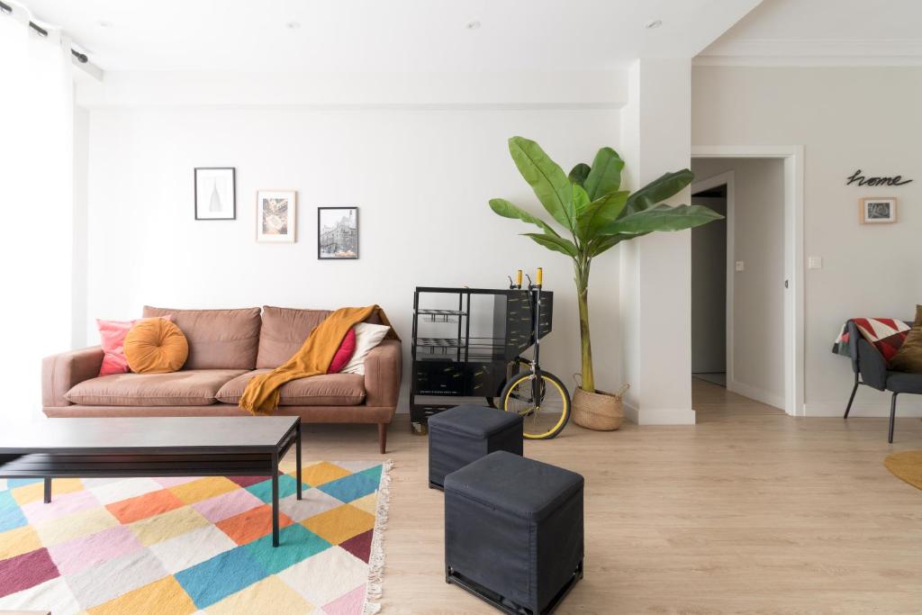 ein Wohnzimmer mit einem Sofa und einer Topfpflanze in der Unterkunft BILBAO ARGIA in Bilbao