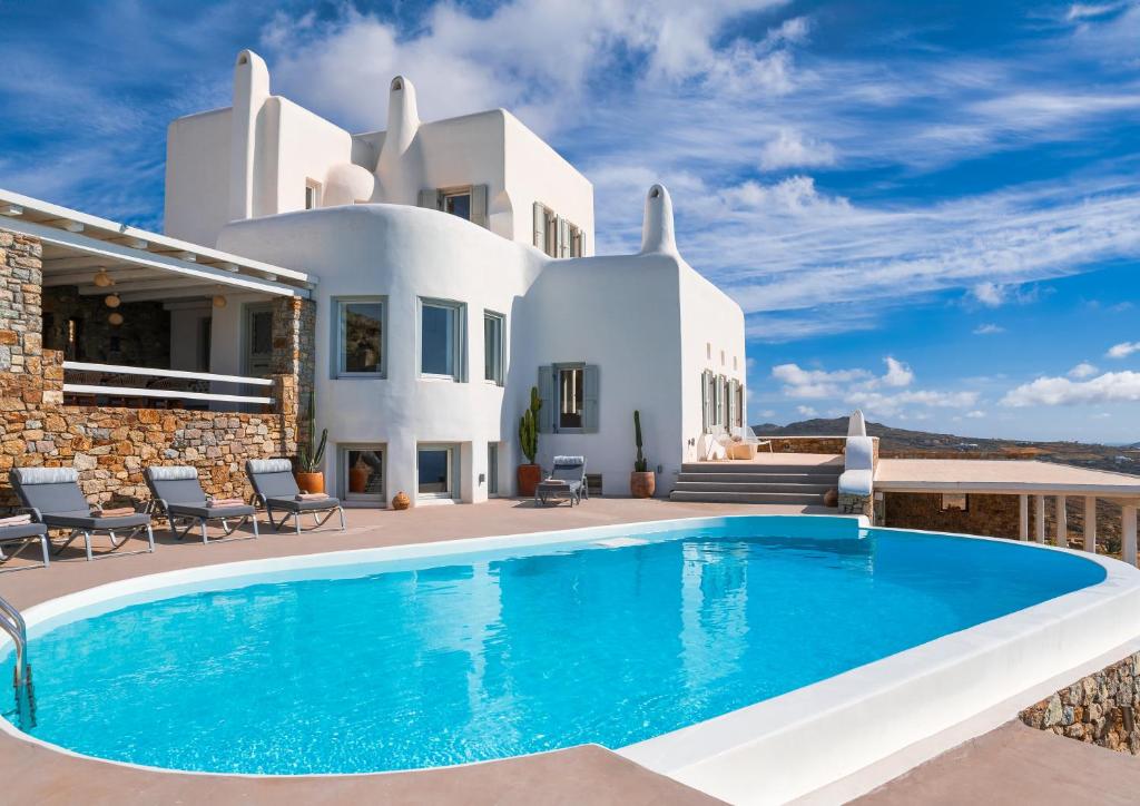 a villa with a swimming pool in front of a house at Velanos Villa in Plintri