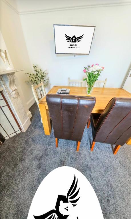 ハートルプールにあるAngel Apartmentsの木製のテーブルと椅子のあるダイニングルーム