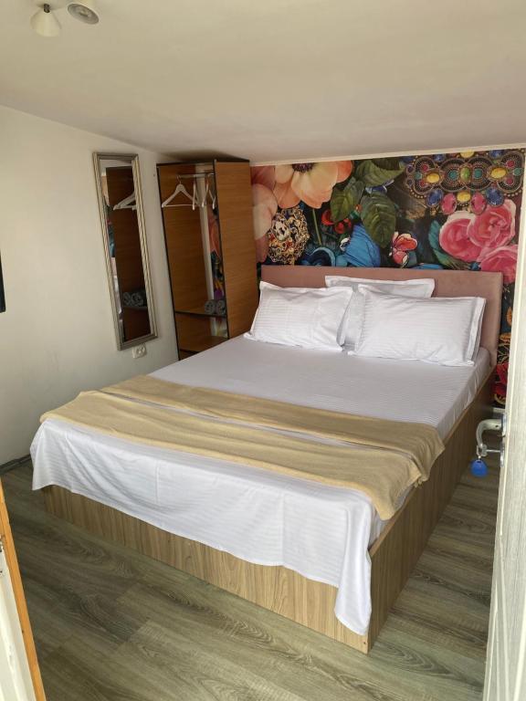 エフォリエ・ノルドにあるThe house of rosesのベッドルーム1室(壁に絵画が描かれた大型ベッド1台付)