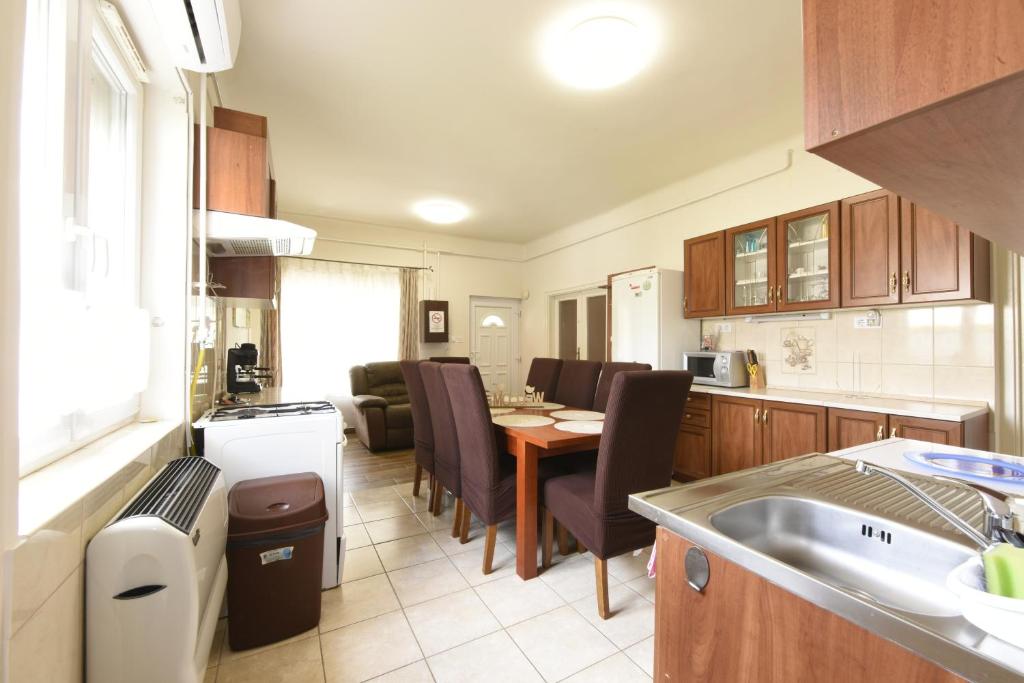 a kitchen and living room with a table and a dining room at Milán Apartment in Nyíregyháza