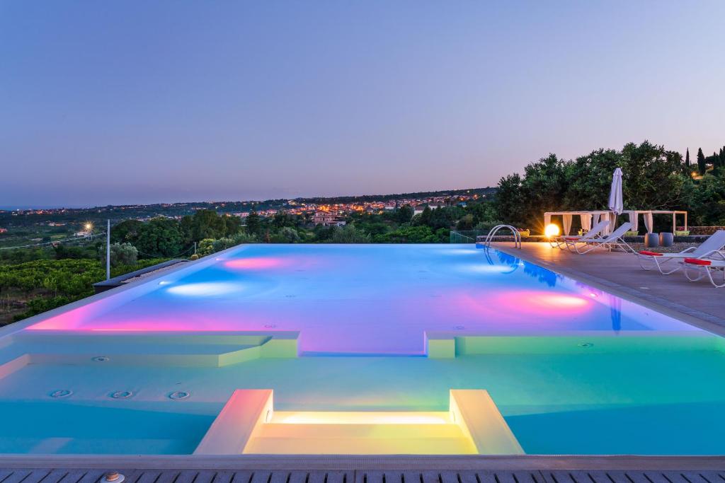 - une grande piscine éclairée la nuit dans l'établissement Kepos Etna Relais & Exclusive Spa, à Santa Venerina