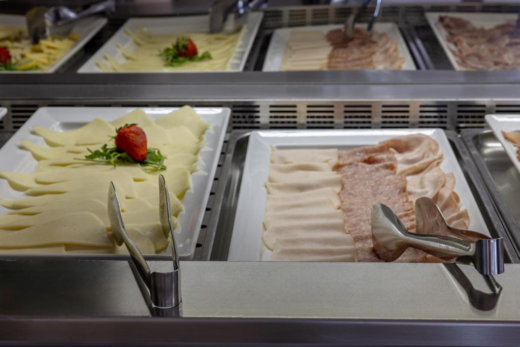 a display case with different types of cheese at Hotel Continental in Caorle