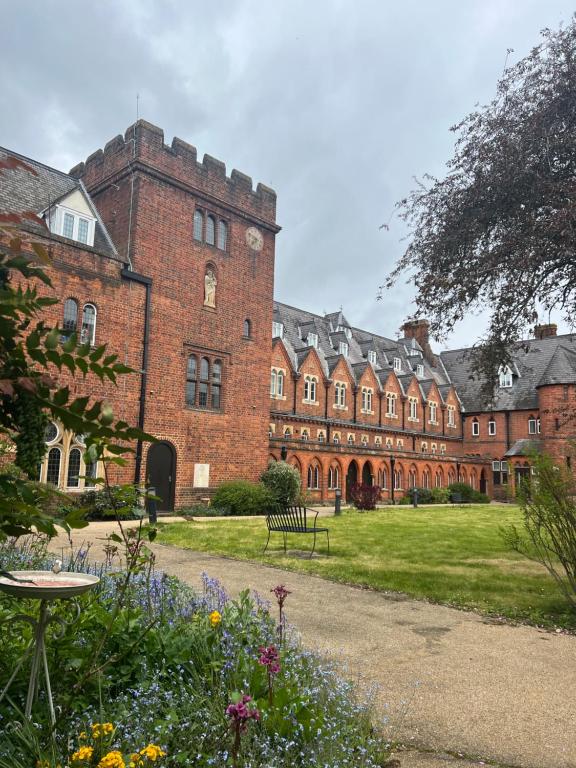 溫莎的住宿－Victorian convent，一座大型红砖建筑,前面有一个花园