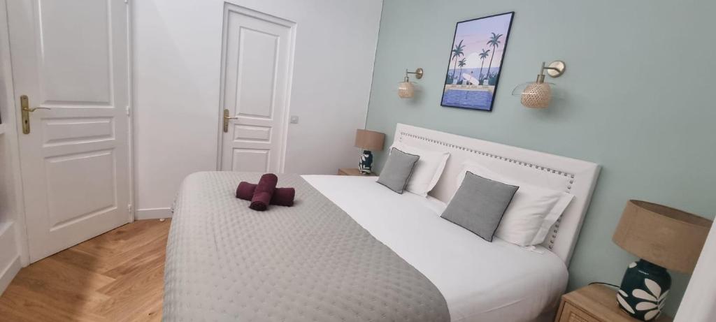 - une chambre dotée d'un lit blanc avec un ours en peluche dans l'établissement Cannes Meynadier: Superbe appartement trois pièces, à Cannes