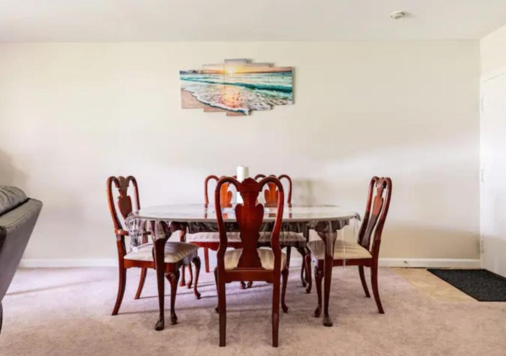 una mesa de comedor con sillas y una pintura en la pared en Two Bedroom Apartment in Norwood en Norwood