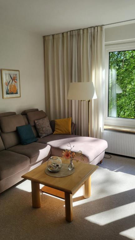 een woonkamer met een bank en een salontafel bij Kurpark Appartement in Glücksburg