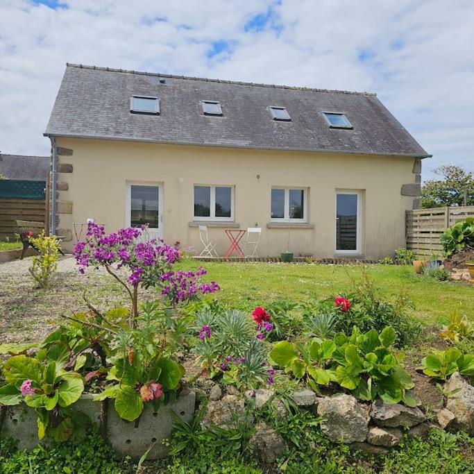 une maison avec des fleurs devant une cour dans l'établissement Maison bretonne rénovée proche bourg et plages, à Plouguerneau