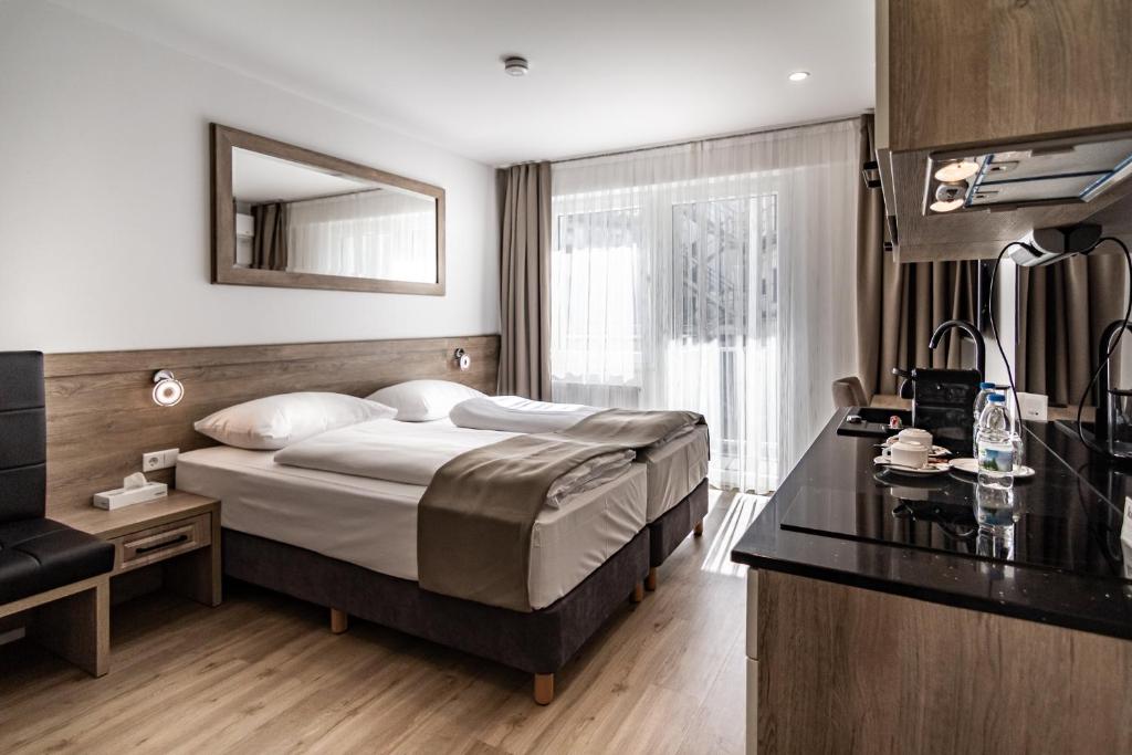 a hotel room with a bed and a desk at Sleep Inn Düsseldorf in Düsseldorf