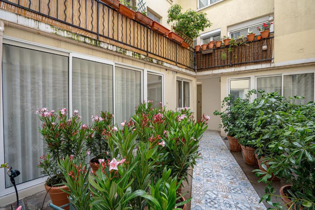 un balcón con plantas y flores en un edificio en Pied A Terre Arts et Métiers, en París