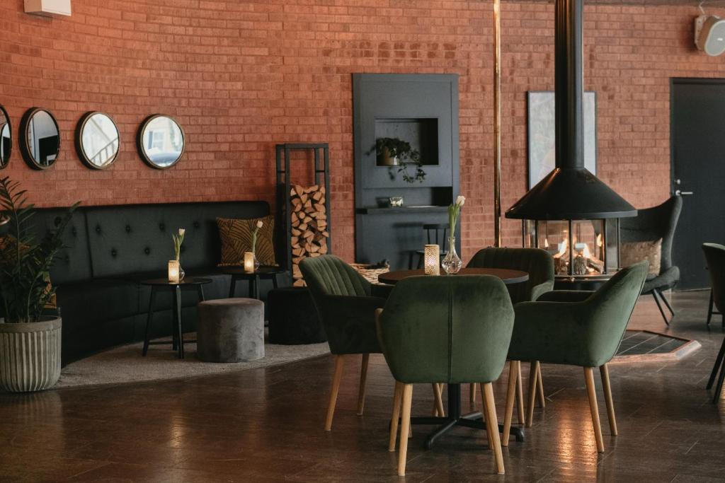 comedor con mesa, sillas y pared de ladrillo en Quality Hotel Galaxen, en Borlänge
