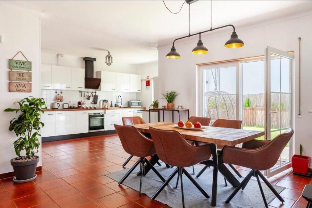 una cucina e una sala da pranzo con tavolo e sedie in legno di Casa do alqueva a Reguengos de Monsaraz