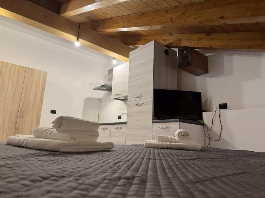 een kamer met een tv en een bed met handdoeken bij Comfort Room 1 Dogana Svizzera in San Fermo della Battaglia