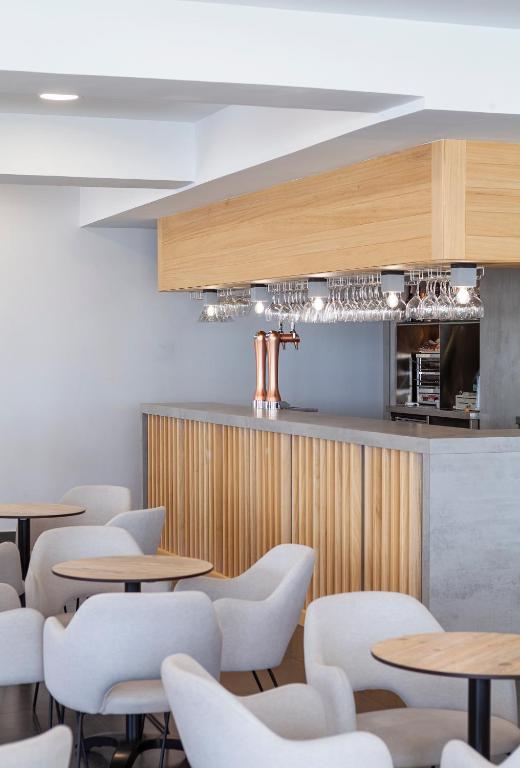 a restaurant with wooden tables and white chairs at Hotel Brisa in Benidorm