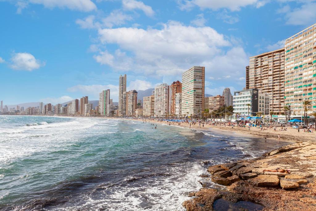 a beach in front of a city with tall buildings at Hotel Brisa in Benidorm