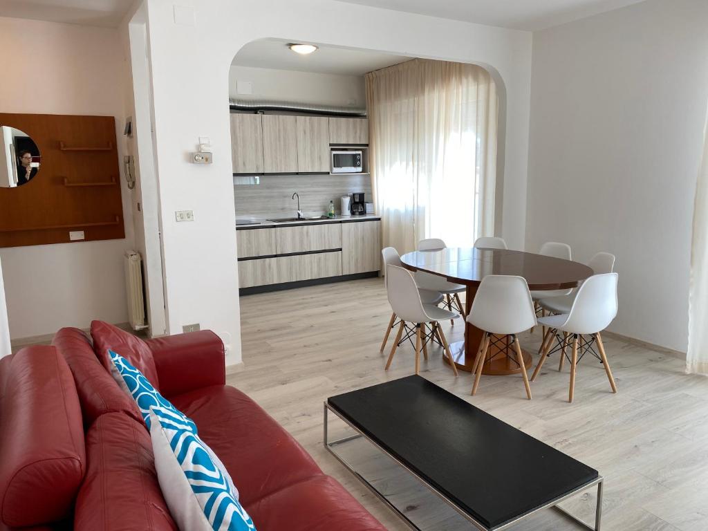 Una sala de estar con un sofá rojo y una mesa. en Casa Eva, en Bibione