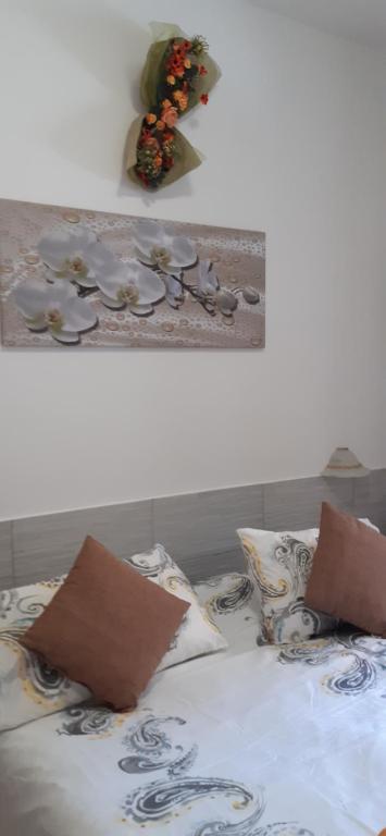 ein Bett mit zwei Kissen und einem Bild an der Wand in der Unterkunft Pan di Zucchero in Iglesias