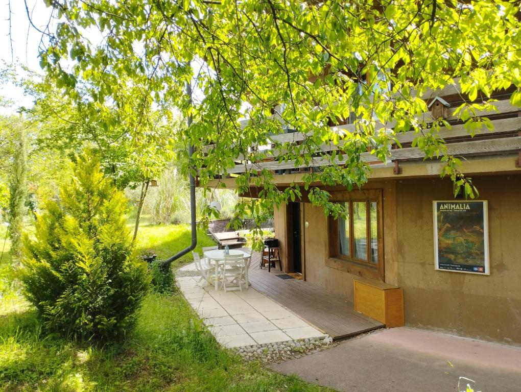 a porch of a house with a table and chairs at Le Nid du Chat Noir - Gîte La Maison Alvéole in Sciez