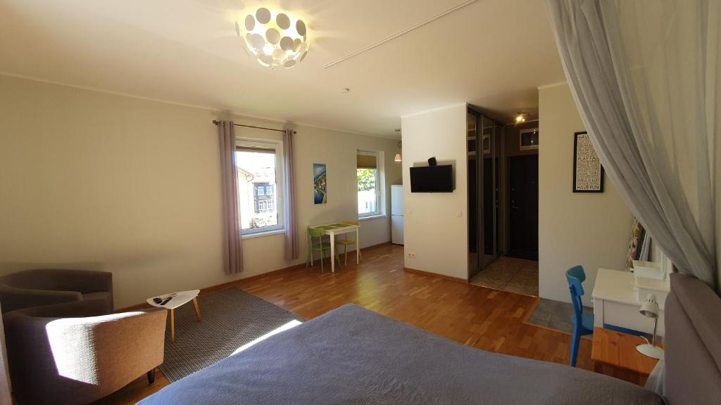 Apartment in Kalamaja في تالين: غرفة نوم مع سرير وغرفة معيشة