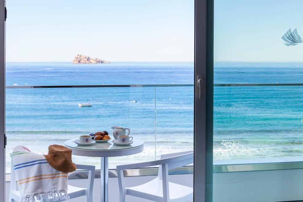 a table and chairs with a view of the ocean at Hotel Brisa in Benidorm