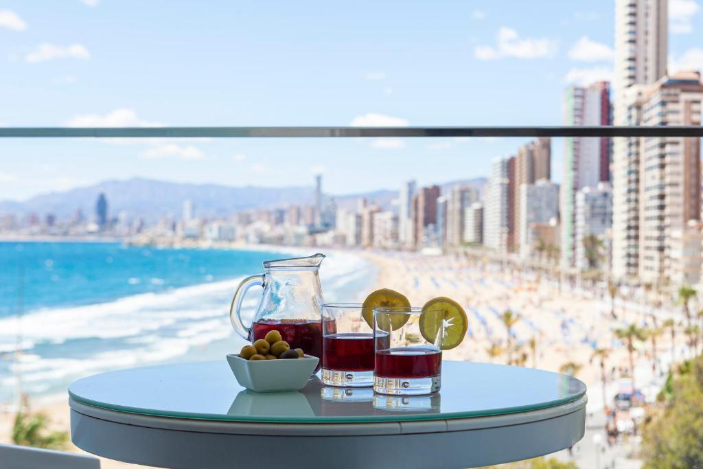 a table with a drink and a bowl of fruit on a beach at Hotel Brisa in Benidorm