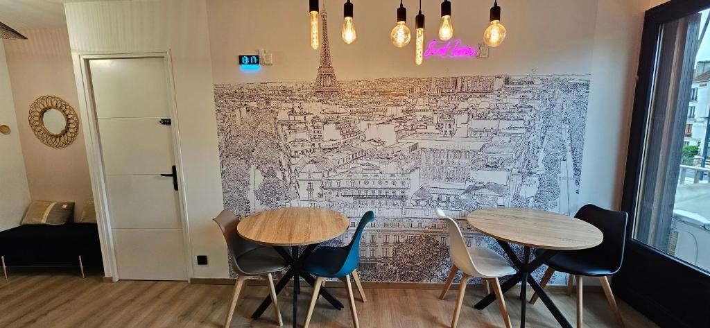 two tables and chairs in front of a wall with a map at Maison des voyageurs Cerise - PARIS ORLY in Choisy-le-Roi