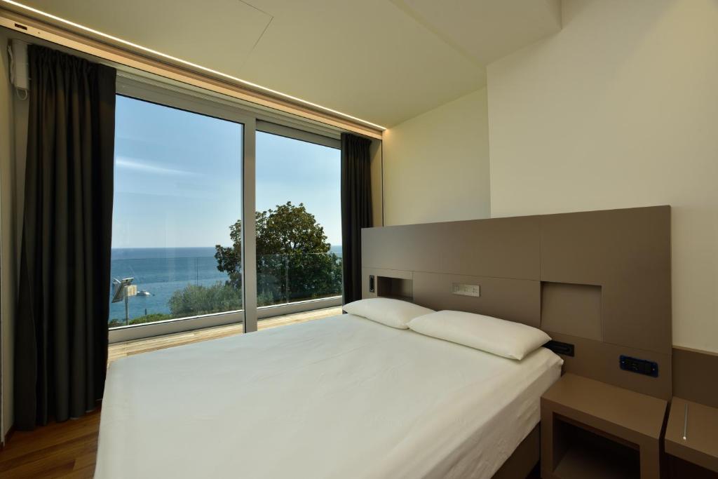 ein Schlafzimmer mit einem großen Bett und einem großen Fenster in der Unterkunft Hotel Le Roi in Varraze