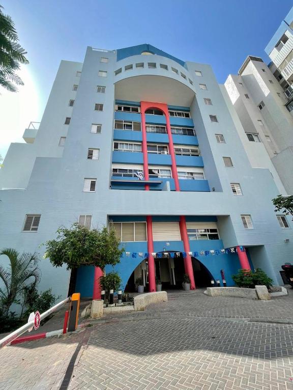 a large white building with red columns at Netanya Sea Studio in Netanya