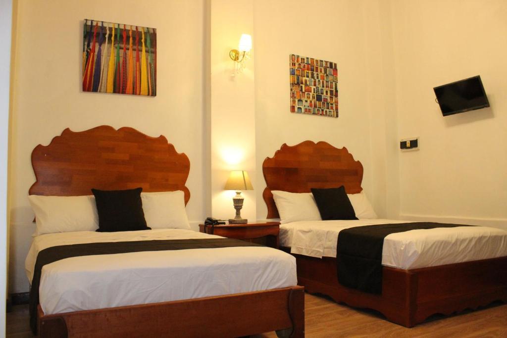 two beds in a hotel room with two beds at Epoca Iquitos in Iquitos