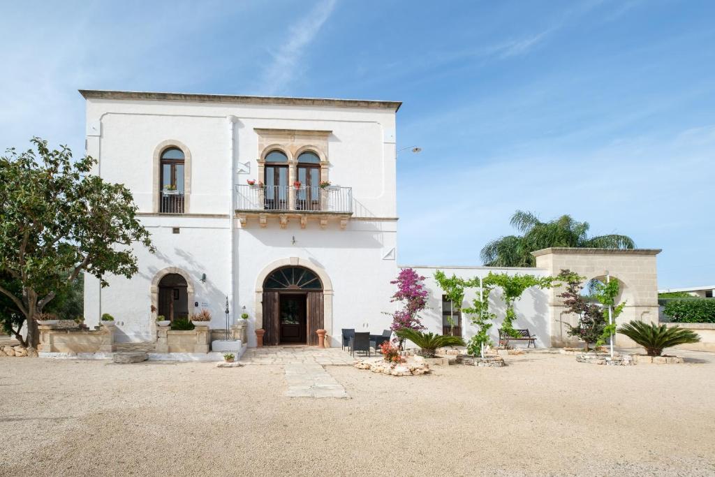 a white house with a balcony on top of it at Borgo Santuri in Ostuni