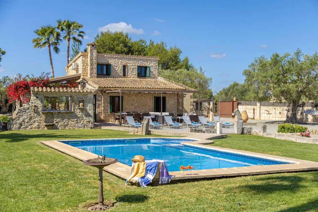 a villa with a swimming pool in front of a house at Villa Can Cosme in Alcudia