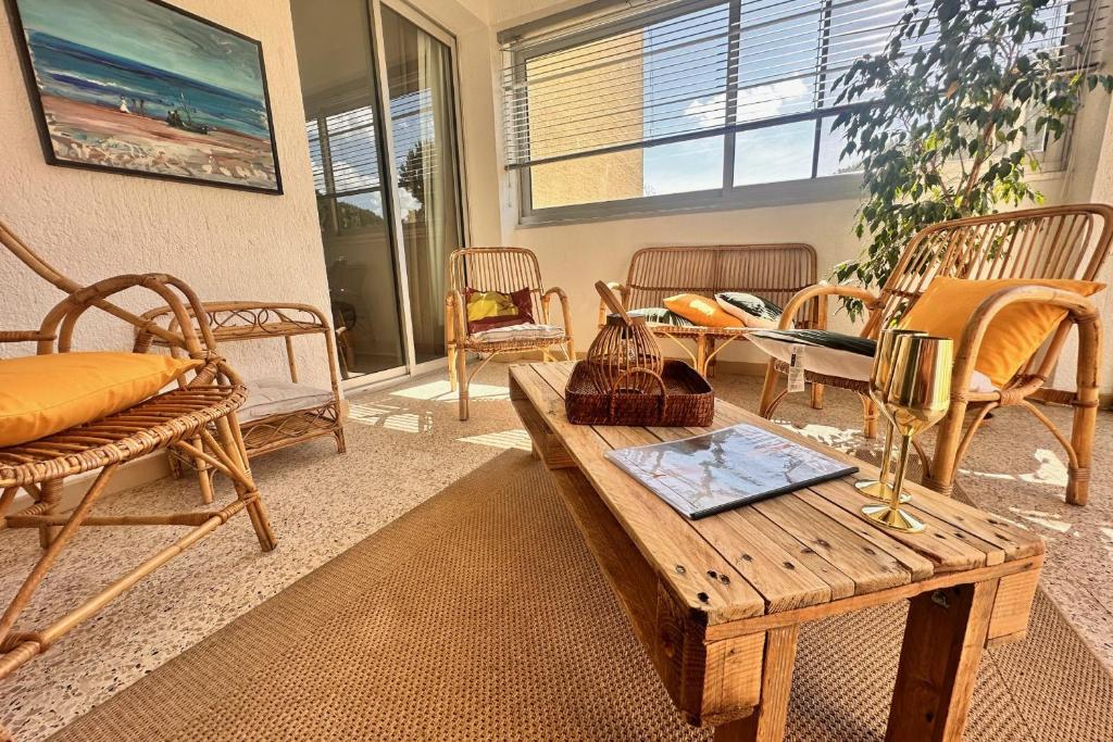 - un salon avec des chaises et une table en bois dans l'établissement L'ANCRE MARINE - Appartement 2 chambres avec parking proche de la plage, au Grau-du-Roi