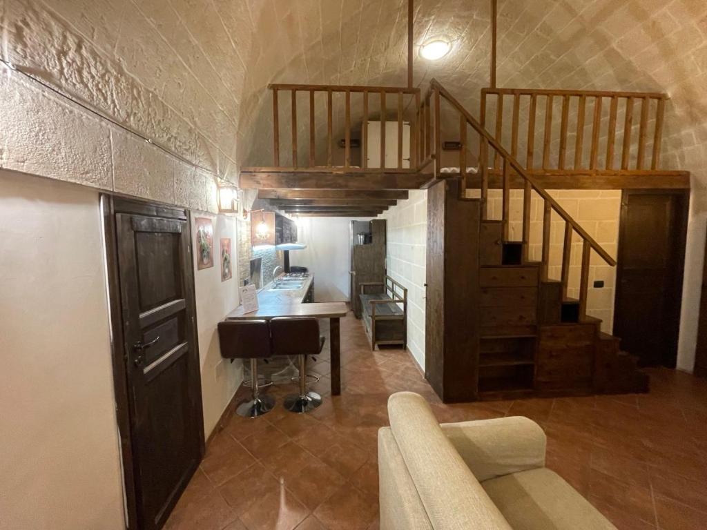 ein Zimmer mit einer Treppe und ein Wohnzimmer mit einem Sofa in der Unterkunft Xenia renting in Massafra