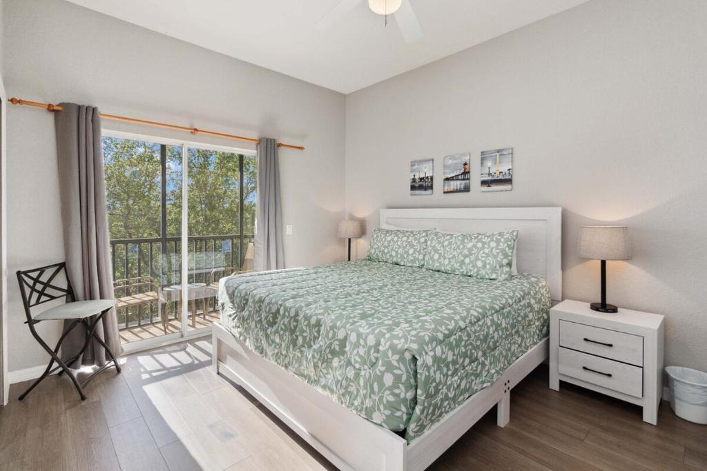 a white bedroom with a bed and a window at Beautiful condo in Bahama Bay in Kissimmee