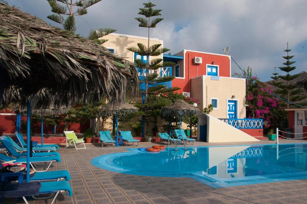 um resort com piscina e cadeiras e um edifício em Villa Michalis em Vlychada