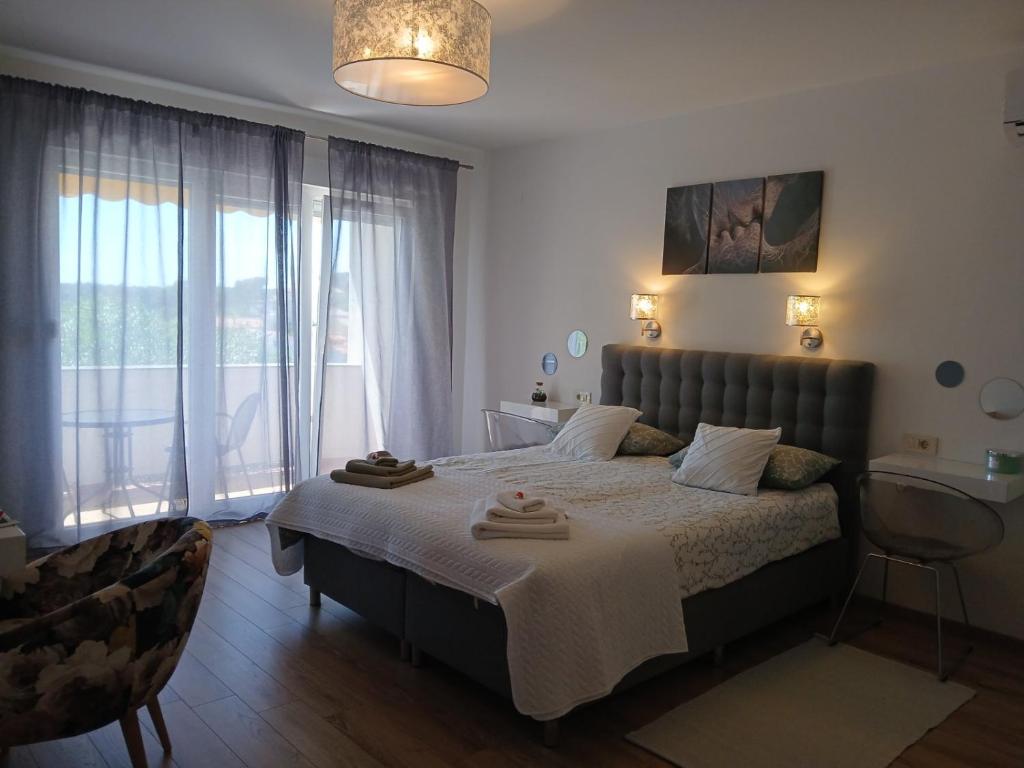 a bedroom with a large bed with a large window at Rooms and Apartments Riviera in Rab