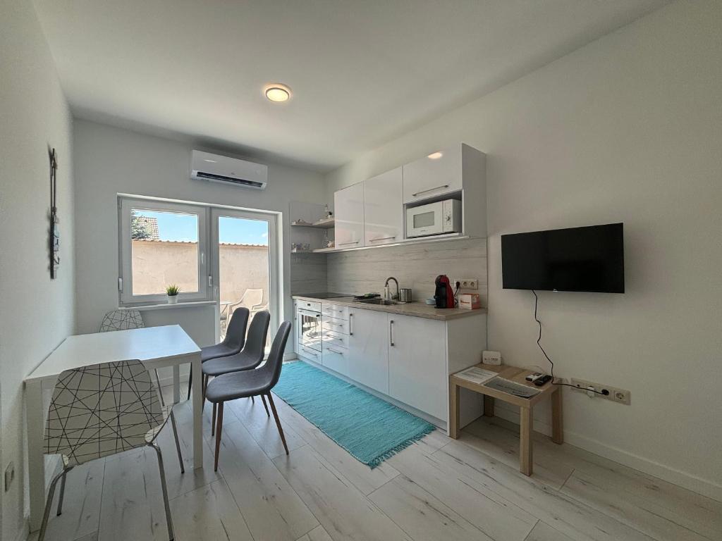 a kitchen and dining room with a table and chairs at SL Apartman Siófok in Siófok
